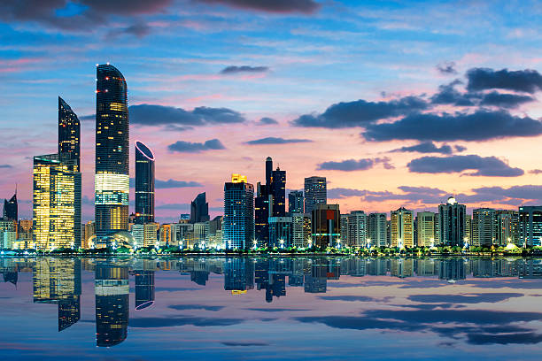 Abu Dhabi skyline at dusk reflected over the water